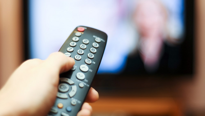 A picture of someone holding a TV remote control