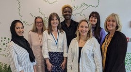 Group of seven NHS employment advisors standing together and smiling