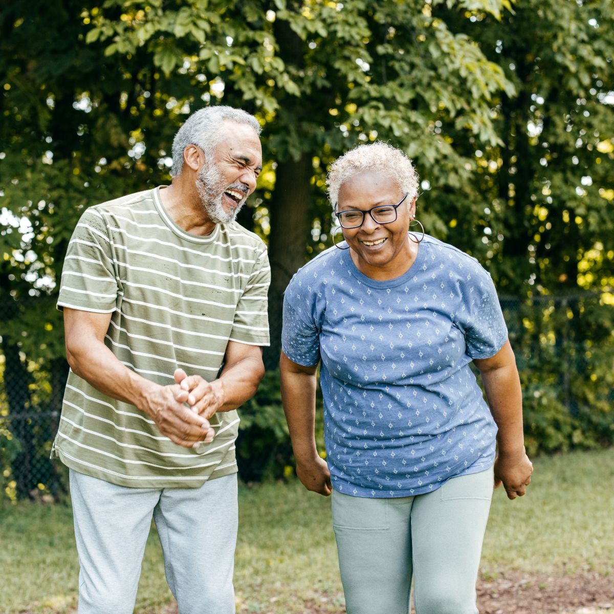 Elderly couple taking a walk in a park on a summer's day, chatting and smiling