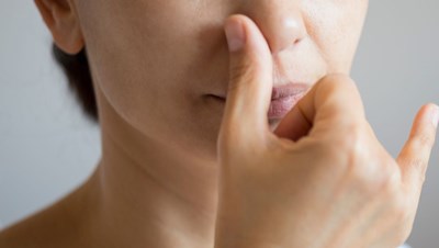 A woman demonstrating the alternate nostril breathing technique 